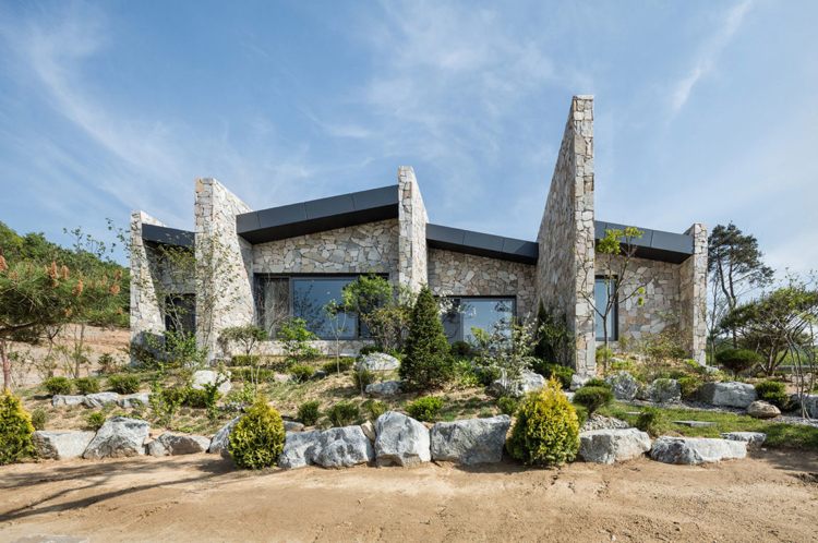 Bungalow Haus -naturstein-modernes-wohnen-garten-findlinge-koniferen