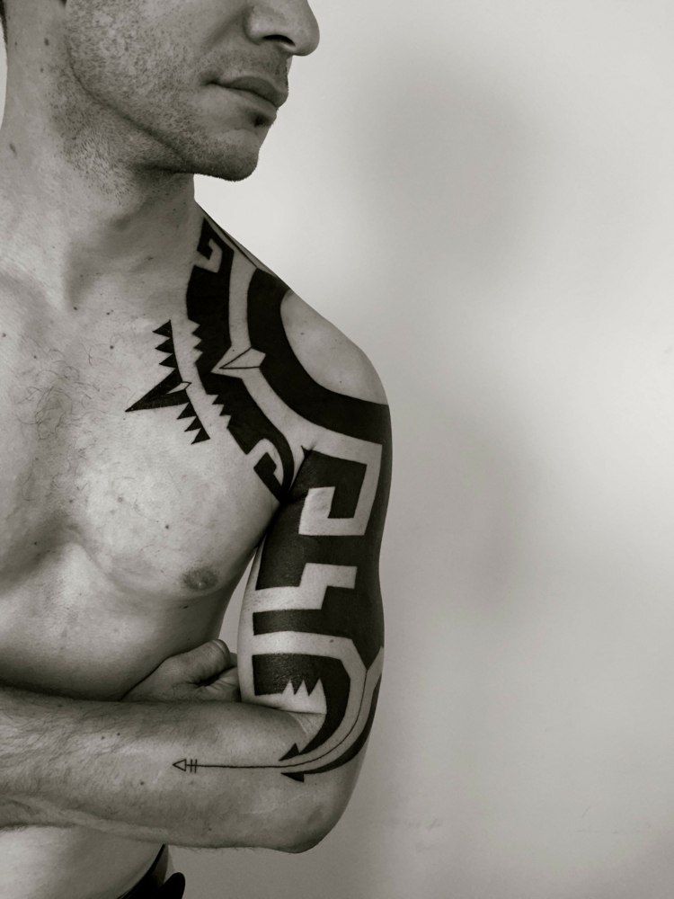 blackwork-tattoo-tribal-männer-schulter-oberarm-pfeil-traditionell-symbole