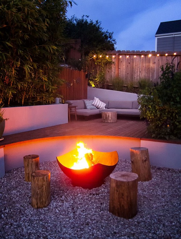 ein-kleiner-garten-feuerstelle-sitzmöglichkeiten-kies-pflanzen