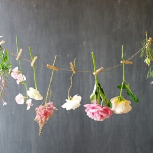 sommerblumen deko girlande-rosen-astilbe-pfingstrose-wiesenblumen-garten-wäscheklammern