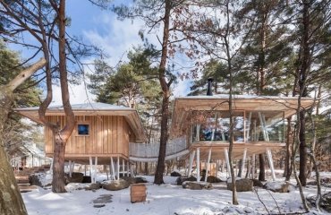 holzhaus-stelzen-zwei-bauten-brücke-ferienhaus-schnee