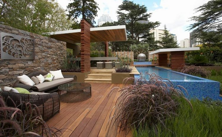 ideen zur gartengestaltung modern-gräser-holz-terrasse-pool-infinity-steinmauer