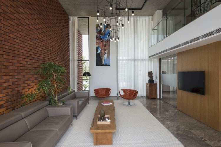 Ziegelfassade als Wärmeschutz wohnzimmer-design-doppelte-raumhöhe-ziegelwand-massivholz-couchtisch-kronleuchter
