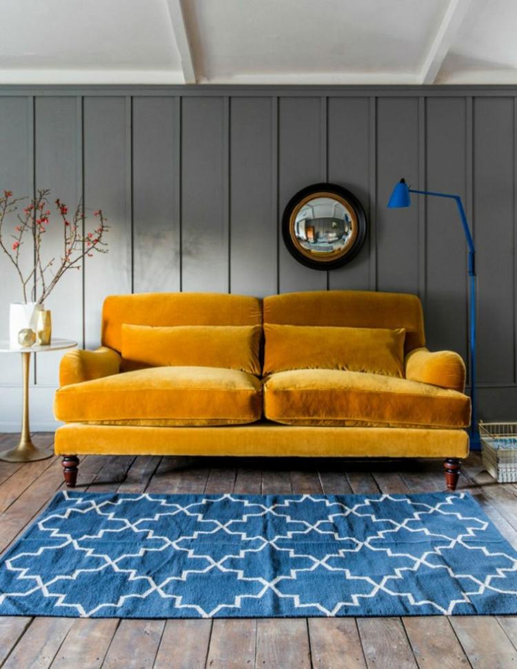couch samt senfgelb blauer teppich parkett rustikal modern einrichten