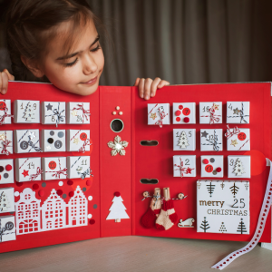 kleines mädchen mit handgemachtem adventskalender
