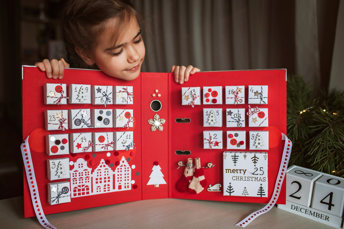 kleines mädchen mit handgemachtem adventskalender