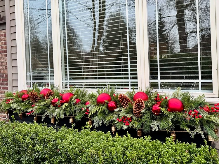 blumenkasten für weihnachten mit immergrünen zweigen zapfen christbaumkugeln