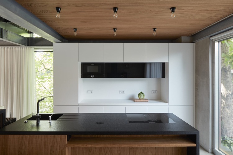 minimalistische einrichtung beton holz moderne küche wiess schwarze arbeitsplatte