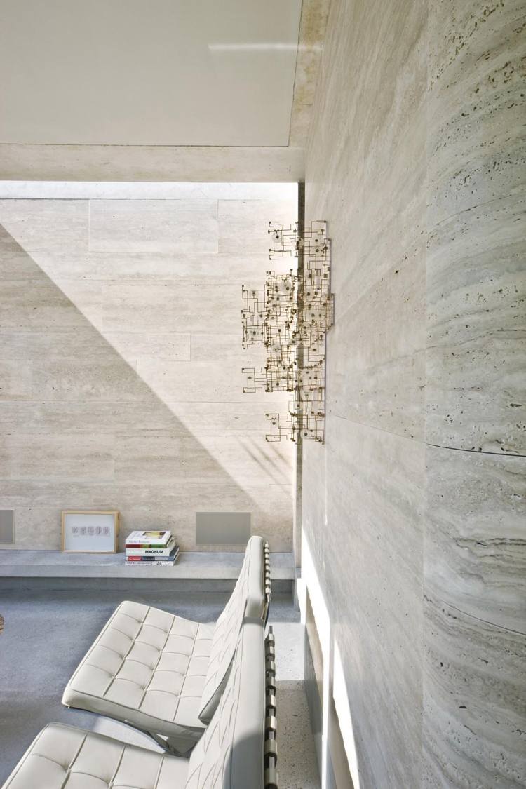 steinverkleidung wand kalkstein hell lichteinfall betonboden minimalistisch