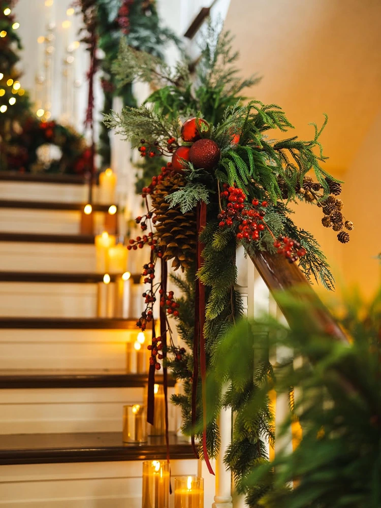treppengeländer mit beeren, zapfen und warmen kerzenlichtern