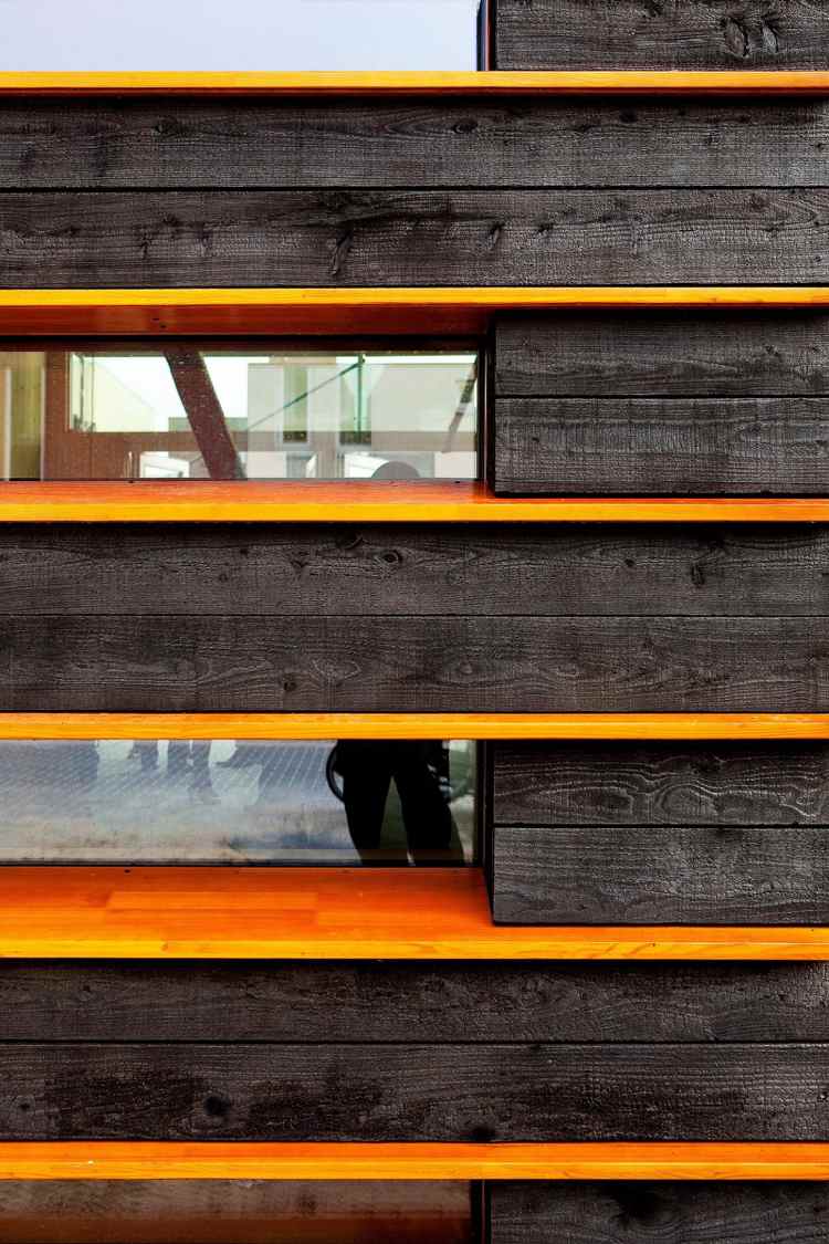 Fassade verkohltes Holz Orange Lack Fenster Kontraste
