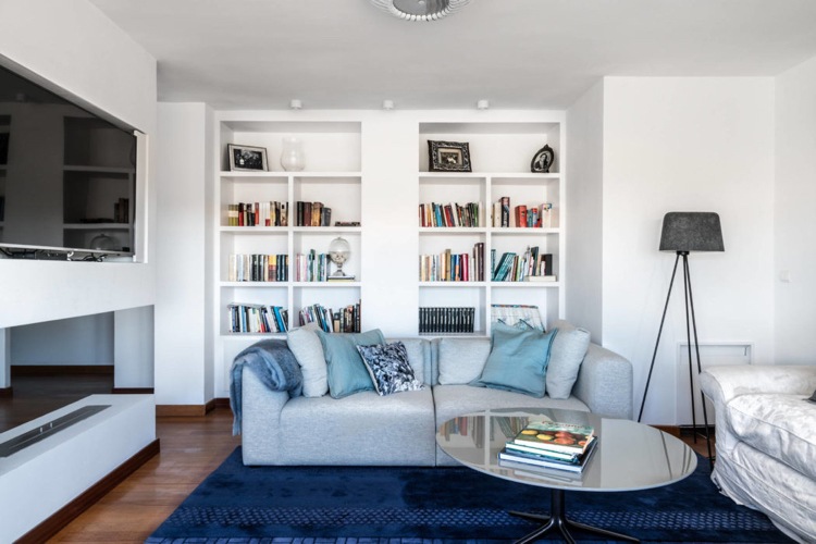 Wohnzimmer Sitzbereich kobaltblauer Teppich Einbau Wandregale