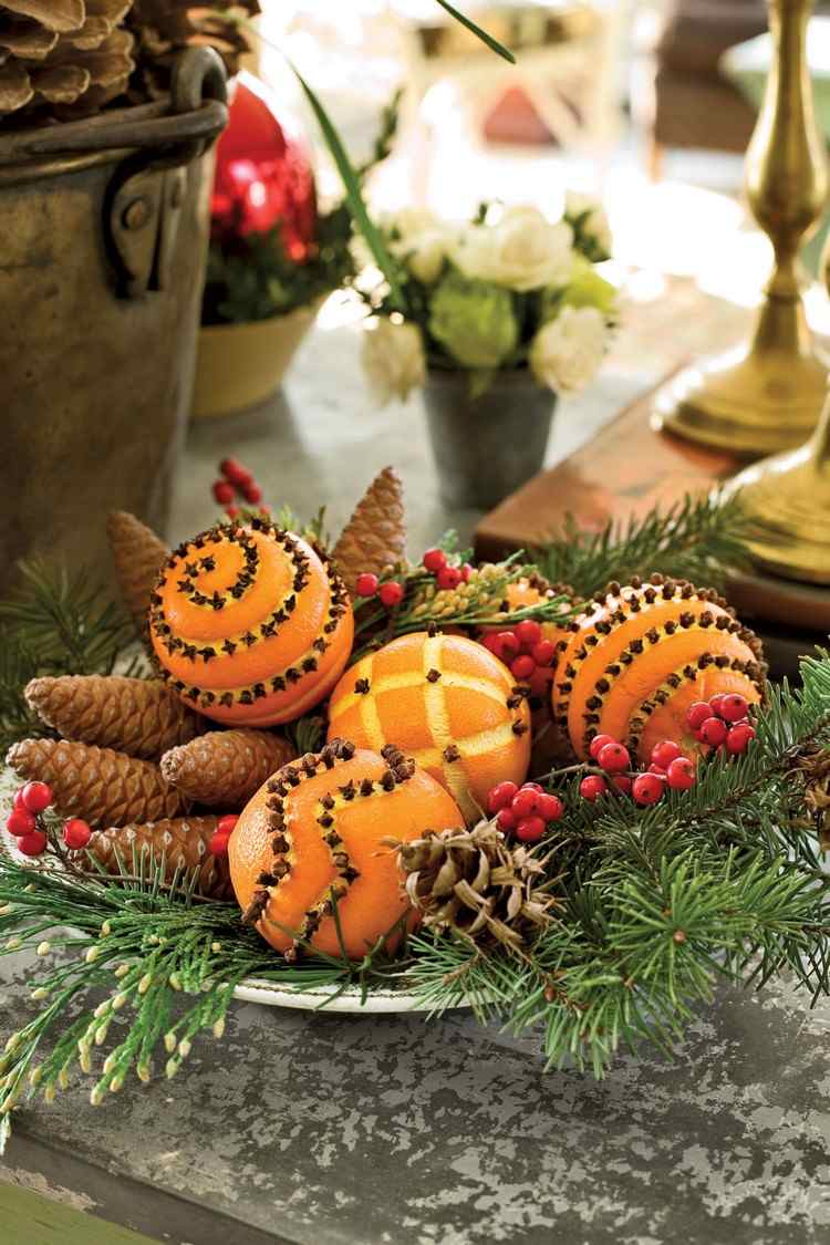 großen teller weihnachtlich dekorieren gespickte orangen tannenzapfen