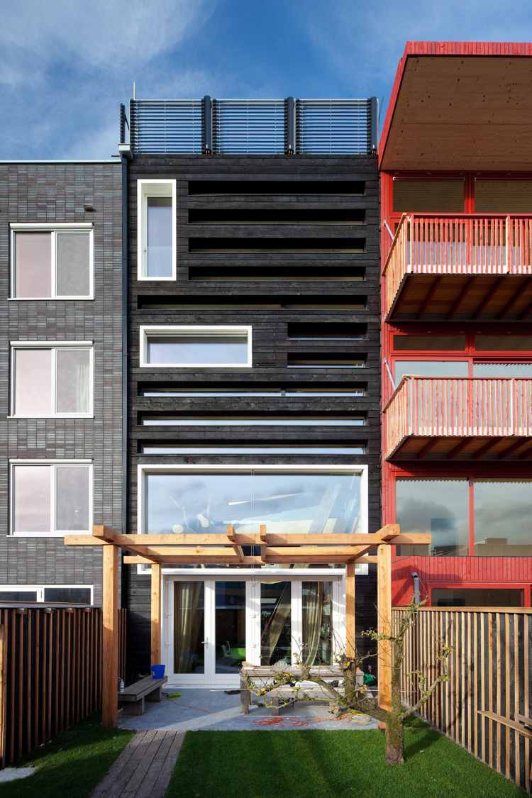 schmales Reihenhaus Fassade verkohltes Holz Hinterhof Pergola