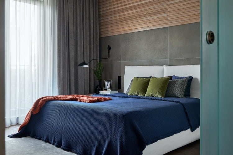 warme farbtöne holzverkleidung schlafzimmer grau tagesdecke dunkelblau
