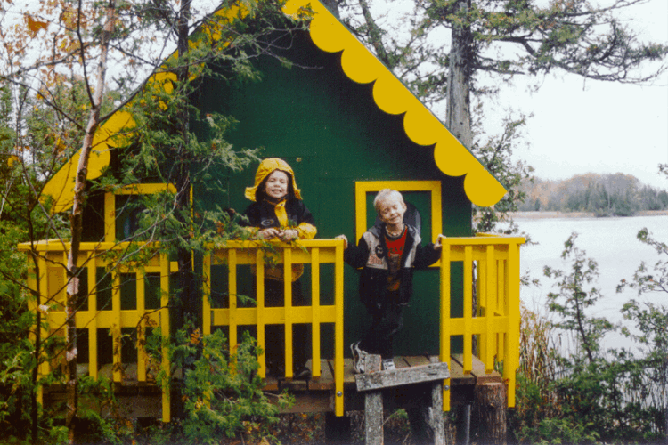 Baumhaus für Kinder grüne Fassade und gelbe Geländer