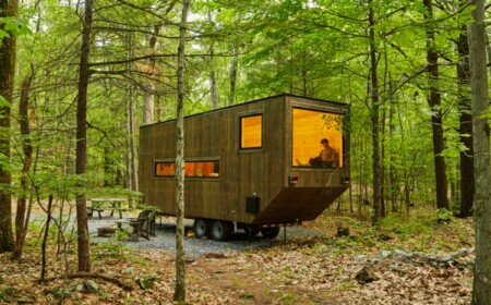 waldhaus aus holz natur räder fenster dunkle fassade