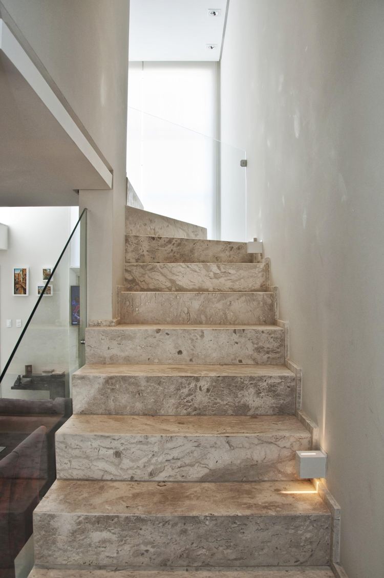 halbgewendelte Treppe Granitstein Glasgeländer Wandleuchten