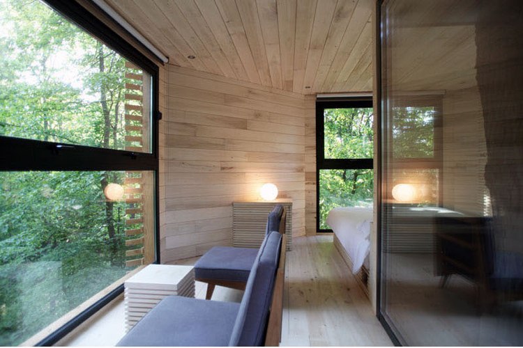 übernachten baumhaus natur interieur panoramafenster aussicht sitzmöglichkeiten
