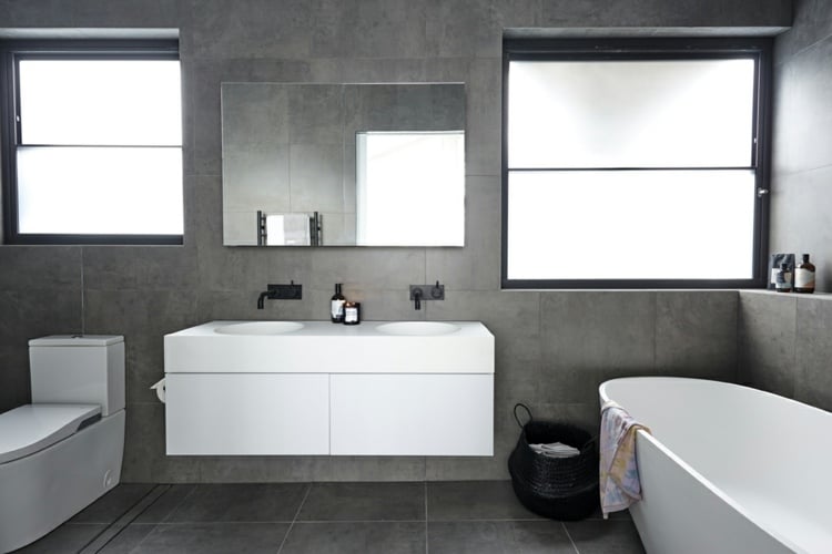 hell minimalistisch eingerichtet marmor grau badezimmer möbel schlichtes design schwarze armaturen