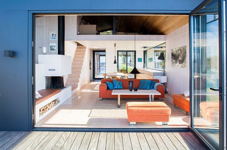 moderne Hütte am Ufer Wohnbereich Glasfalttür Terrasse