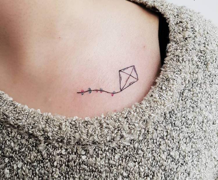 kleines Tattoo Schlüsselbein Drachen in der Luft Frau