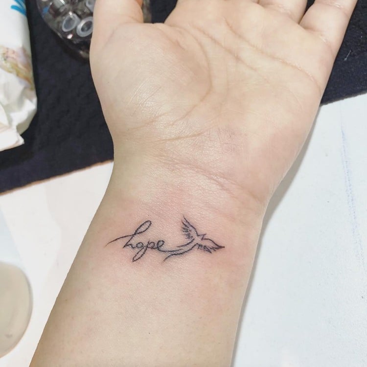 kleines Tattoo Schriftzug Vogel Handgelenk Frau