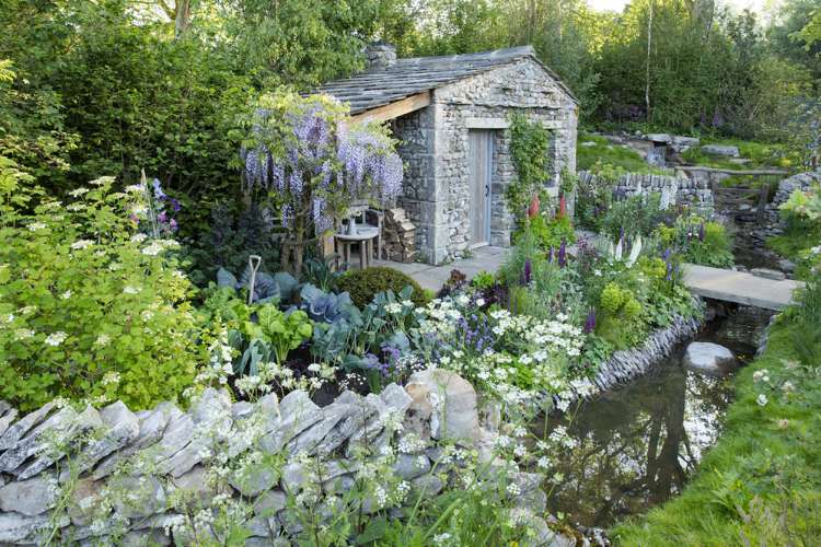 Englischer Garten Steinhütte Blauregen Sitzecke Lupinen