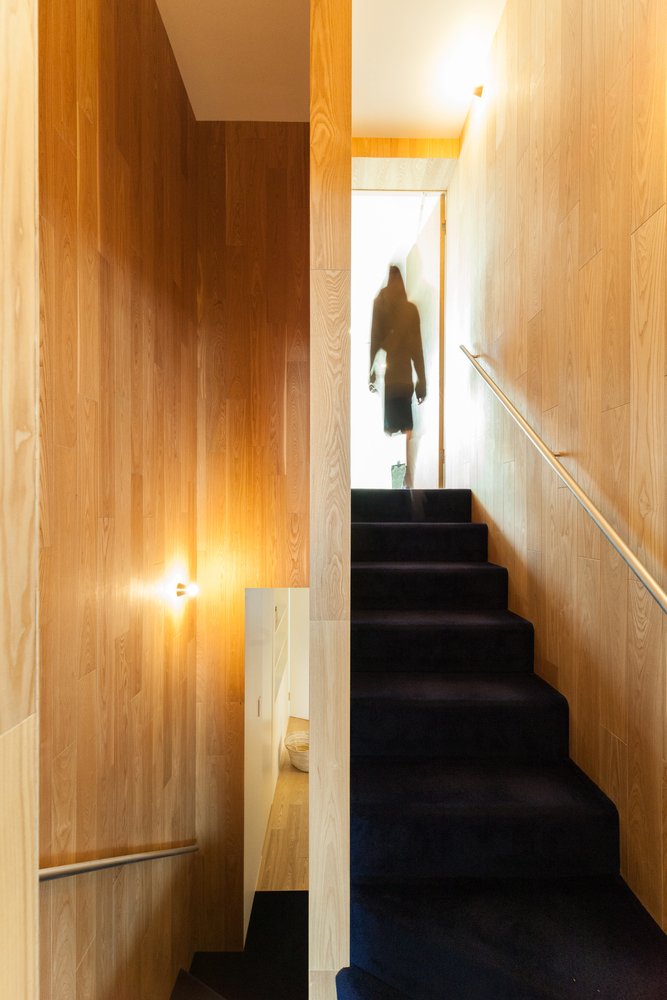 Holz Wandpaneele Stufen schwarzer Teppichboden Edelstahl Handlauf