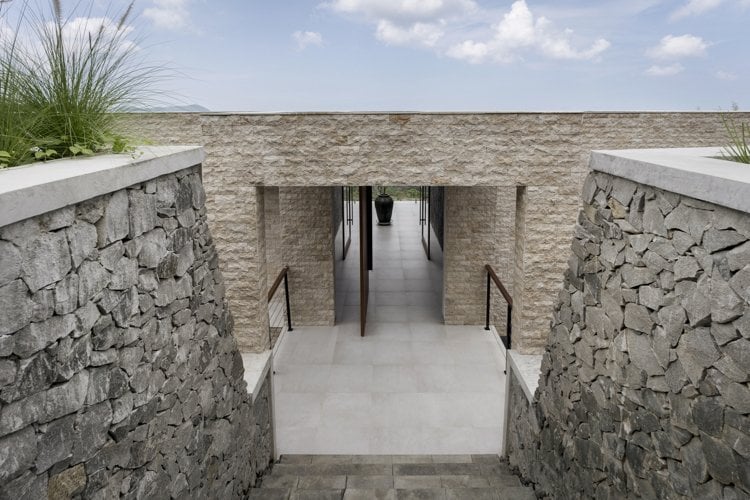 Kalksteinfassade Bruchstein Stützmauer Haus eingang Drehtür