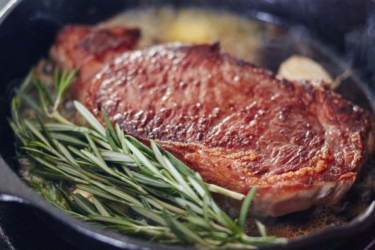 Steak braten in der Gusseisenpfanne Butter Rosmarinzweige