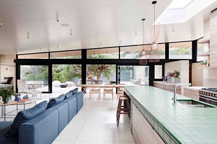bauen mit stampflehm hybridmaterial moderne architektur layer house schichten grün fliesen zweizeilige küche wohnzimmer