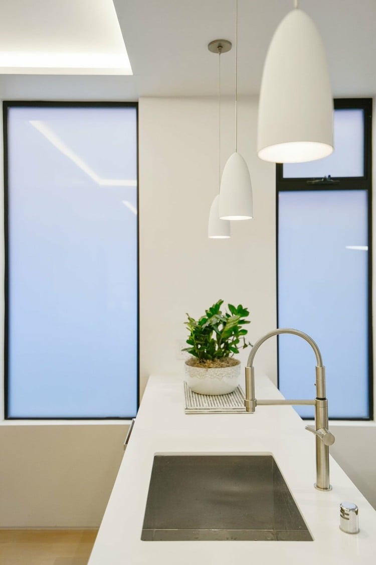 minimalistische küche in weiß pendelleuchten arbeitsplatten reinigen