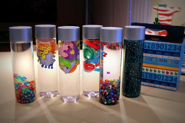 sensory bottles babys kleinkinder entwicklung fördern wasser buchstabenwürfel glitter