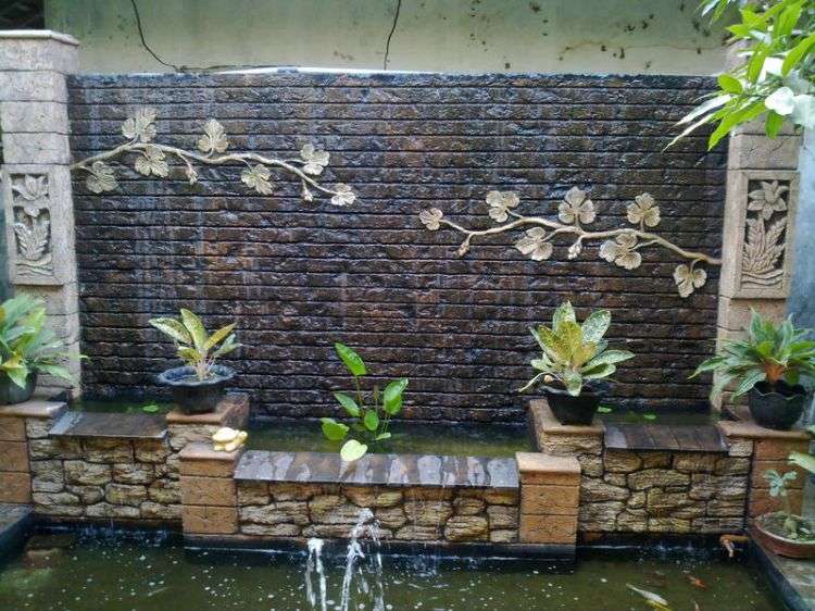 wandbrunnen modern innen außen gestalten steinmauer wasserspiel ranken kaskade teich pflanzen ziegelstein