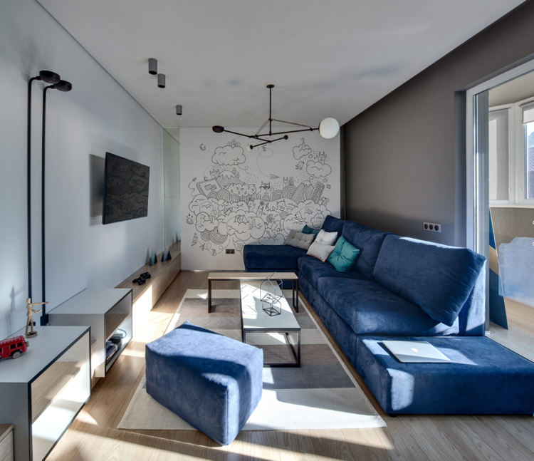 Graue Wandfarbe und heller Holzboden passen zum blauen sofa