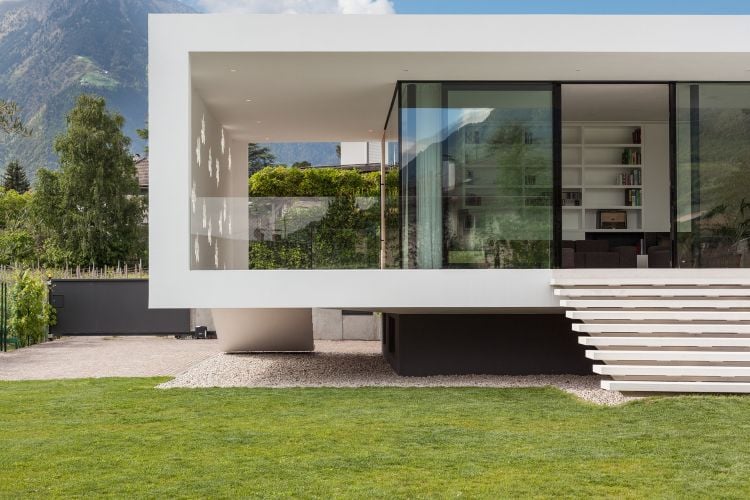 freistrehendes einfamilienhaus modern bauen architektur meran italien pool design einstöckig garten glasschiebetüren garagentor