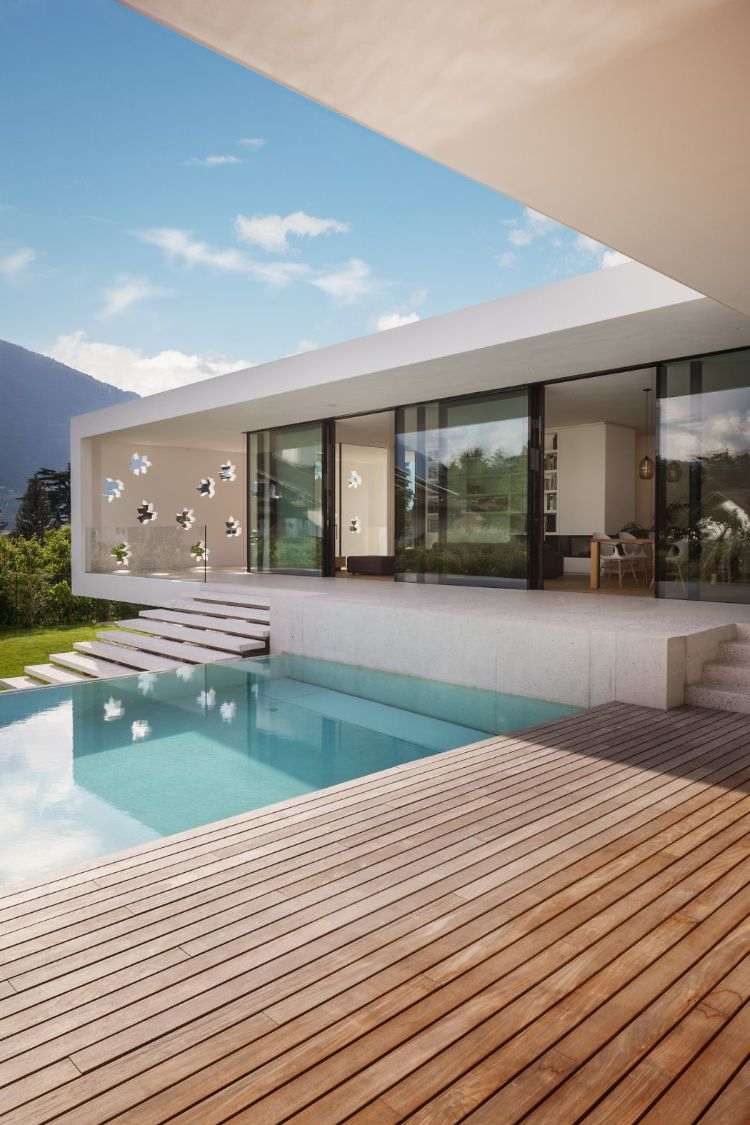 freistrehendes einfamilienhaus modern bauen architektur meran italien pool design einstöckig garten glasschiebetüren holzdielen