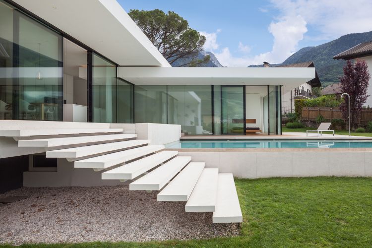 freistrehendes einfamilienhaus modern bauen architektur meran italien pool design einstöckig garten glasschiebetüren treppe seitenansicht