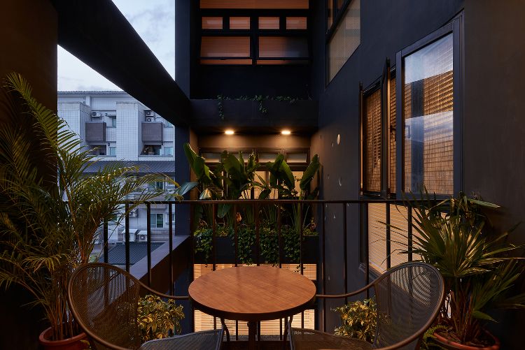 schwarze fassade modern gestalten onyx lit haus taiwan minimalistisch runde löcher design kreise inspiriert von gischt architektur projekt balkon pflanzen