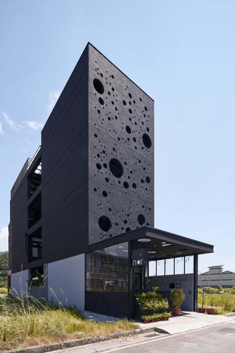 schwarze fassade modern gestalten onyx lit haus taiwan minimalistisch runde löcher design kreise inspiriert von gischt architektur projekt tageslicht