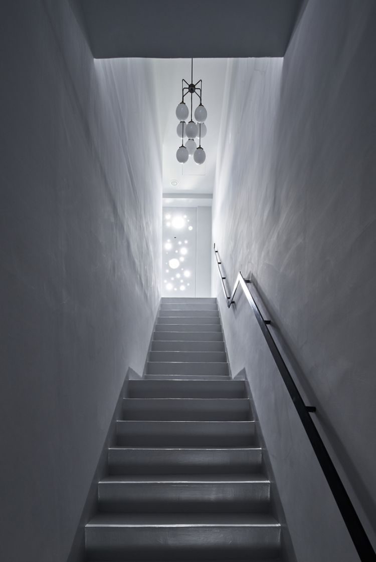 schwarze fassade modern gestalten onyx lit haus taiwan minimalistisch runde löcher design kreise inspiriert von gischt architektur projekt treppe licht