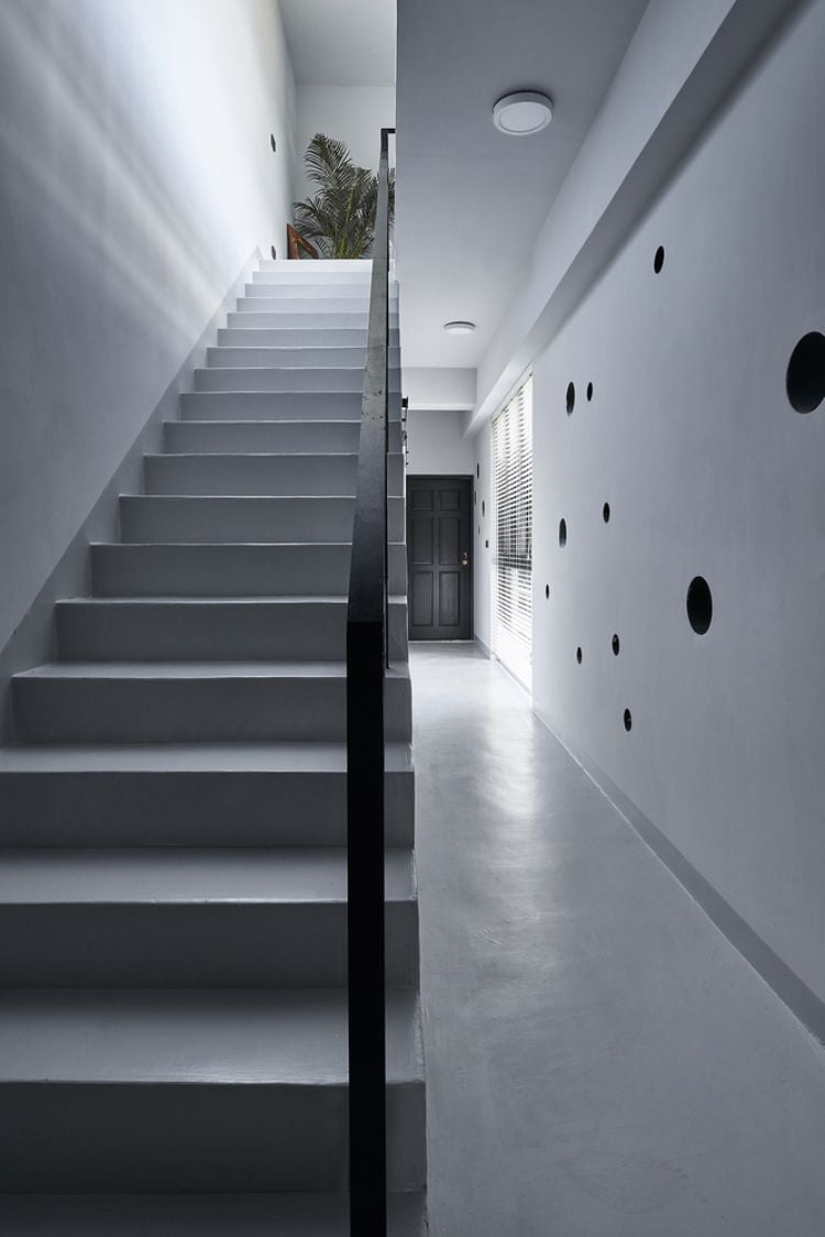 schwarze fassade modern gestalten onyx lit haus taiwan minimalistisch runde löcher design kreise inspiriert von gischt architektur projekt weiß treppe