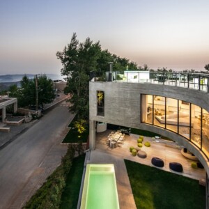 geschwungenes haus aus beton panoramafenster pool