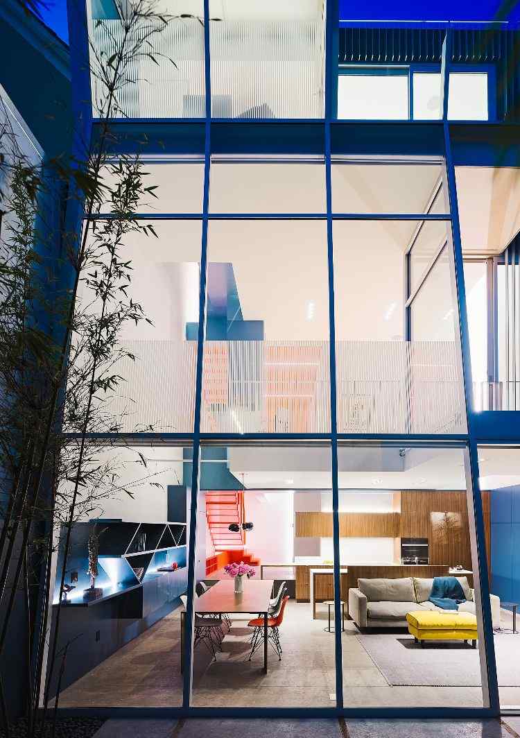haus mit glasfront dreistöckig neubau design glasfenster vorderansicht drei etagen abend