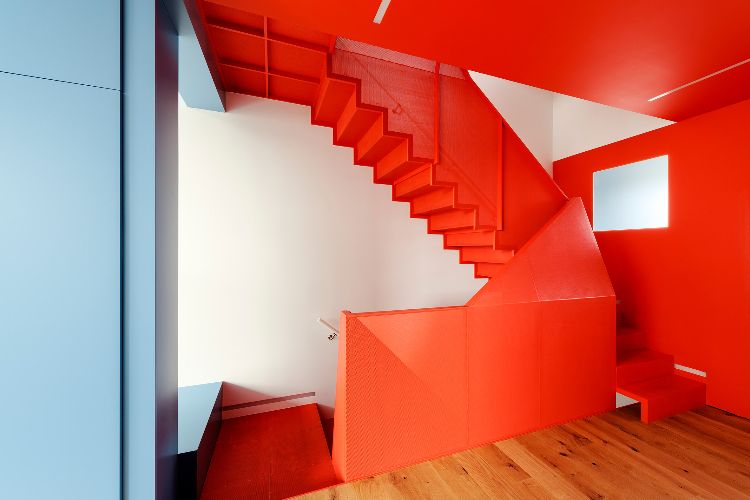 haus mit glasfront dreistöckig neubau design orangenfarben treppenhaus hellblau wand