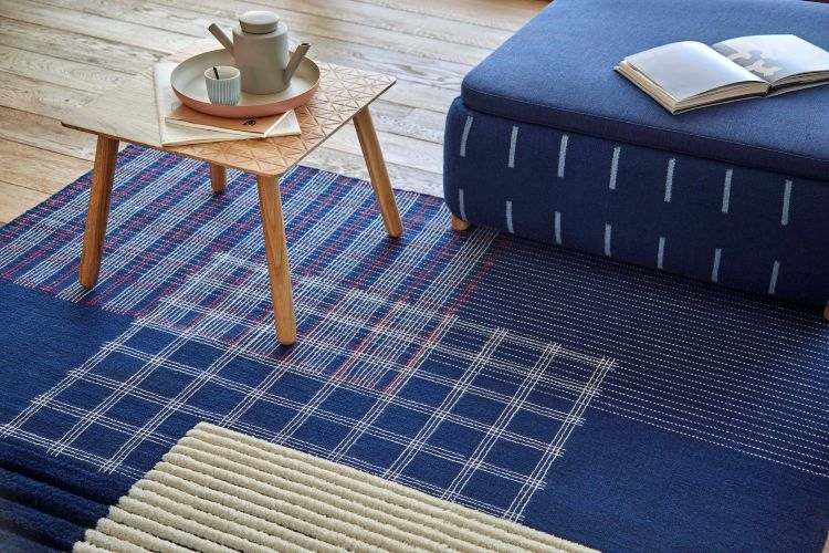 indigo farbe kombinieren indigoblau sofa teppich holztisch buch tablett kanne tasse dielenboden