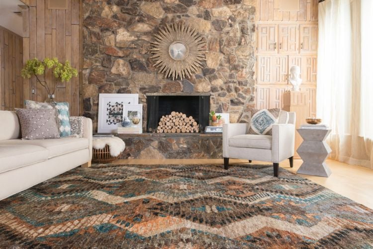 teppich im wohnzimmer moderner landhausstil sofa sessel holzwand kamin naturstein