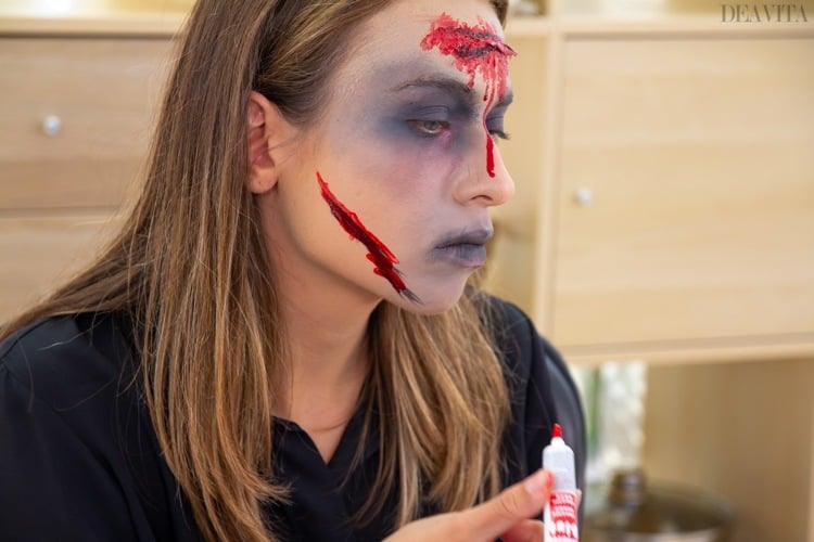 Zombie schminken Kunstblut Wange auftragen
