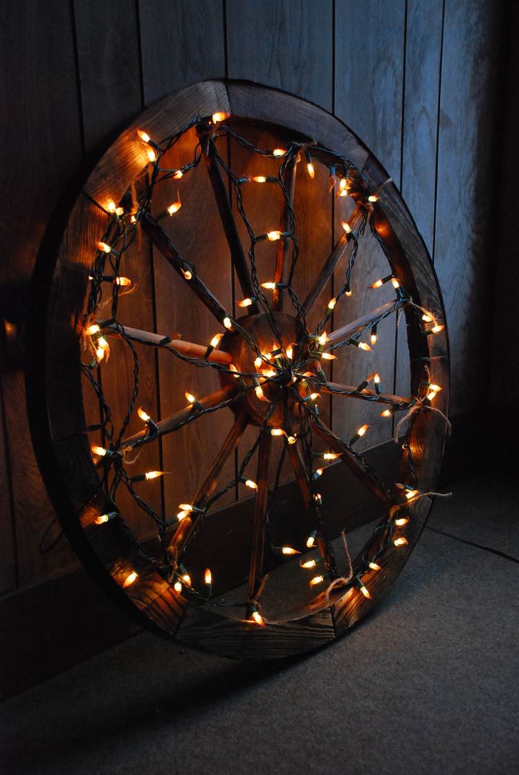 altes Wagenrad mit LED Lichterkette dekoriert